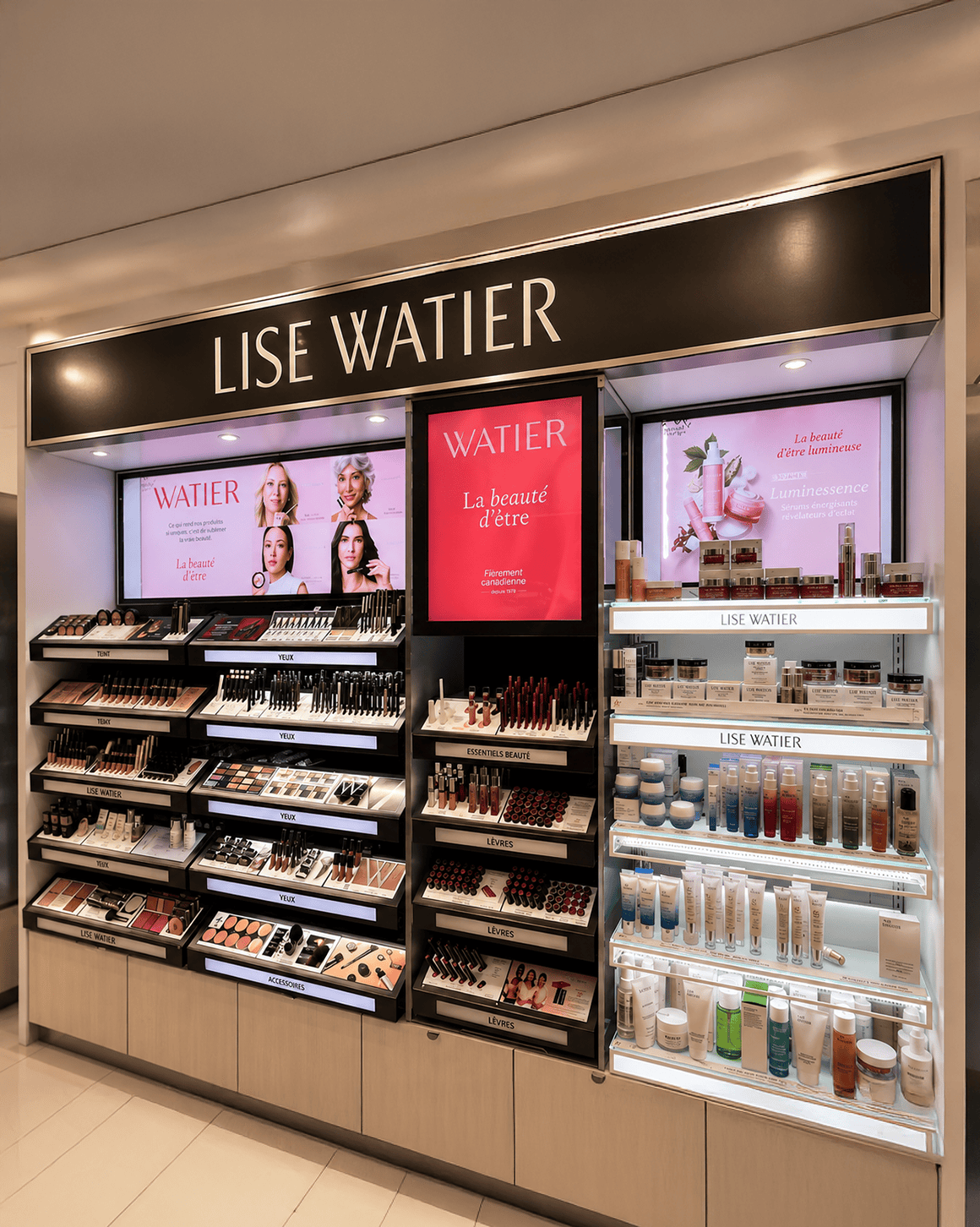 arX Display Lise Watier shop-in-shop beauty bay with illuminated header, digital screens, and tiered cosmetics and skincare shelving